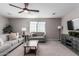 Comfortable living room featuring neutral tones, modern ceiling fan, and ample seating on carpet at 3840 W Brogan Ct, New River, AZ 85087