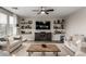 Bright living room featuring modern shelving, ceiling fan, and comfortable sofas on a plush rug at 3840 W Brogan Ct, New River, AZ 85087