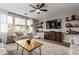 Inviting living room with a cozy seating area, hardwood floors, and a large TV at 3840 W Brogan Ct, New River, AZ 85087