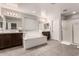 Bright primary bathroom featuring double sinks, large soaking tub, and glass-enclosed shower at 3840 W Brogan Ct, New River, AZ 85087