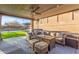 Inviting covered patio featuring a comfortable seating area, ceiling fan, and view of the lush backyard at 3840 W Brogan Ct, New River, AZ 85087