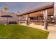 This amazing backyard pergola is well equipped with a large bar, tv, curtains, and ceiling fan at 3840 W Brogan Ct, New River, AZ 85087