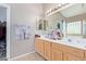 Bright bathroom featuring a double sink vanity, large mirror, and tiled floors at 40915 N Columbia Trl, Anthem, AZ 85086