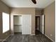 Neutral bedroom features wood-look floors, closet, and white door leading to hallway at 40915 N Columbia Trl, Anthem, AZ 85086
