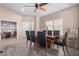 Formal dining area with wood-look floors, a modern ceiling fan, and a view to the backyard at 40915 N Columbia Trl, Anthem, AZ 85086