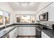 Modern kitchen with white cabinets, black countertops, and stainless steel appliances at 4346 E Corral St, Phoenix, AZ 85044