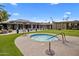 Outdoor hot tub surrounded by lush green grass and tables with umbrellas, perfect for relaxing and entertaining at 4800 N 68Th St # 225, Scottsdale, AZ 85251