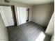 This bedroom features neutral walls, gray wood floors and a closet with sliding doors at 5420 W Lynwood St, Phoenix, AZ 85043