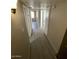 This hallway features neutral walls, gray wood floors and multiple doorways to other rooms at 5420 W Lynwood St, Phoenix, AZ 85043