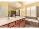 Bright bathroom featuring a double sink vanity, soaking tub, and a large mirror for a luxurious feel at 583 W Bismark St, San Tan Valley, AZ 85143