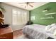 Bright and airy bedroom featuring a large window with shutters, ceiling fan, and stylish decor at 583 W Bismark St, San Tan Valley, AZ 85143