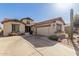 Two-story home with three car garage, desert plants, and covered front porch at 583 W Bismark St, San Tan Valley, AZ 85143