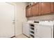 Functional laundry room with upper cabinets, washer, and dryer, for efficient household tasks at 583 W Bismark St, San Tan Valley, AZ 85143
