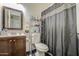 Cozy bathroom featuring a dark wood vanity and a shower with an elegant, patterned dark curtain at 5962 W Townley Ave, Glendale, AZ 85302