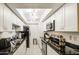Well-lit kitchen features a suite of stainless steel appliances, granite counters, and bright white cabinets at 5962 W Townley Ave, Glendale, AZ 85302