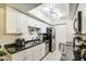 Modern kitchen with white cabinetry, stainless steel appliances, and sleek black countertops at 5962 W Townley Ave, Glendale, AZ 85302