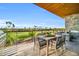 This spacious covered balcony features seating, dining table, grill, stone wall, and panoramic views at 6331 E Phoenician Blvd # 6, Scottsdale, AZ 85251