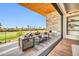 Inviting covered balcony with stone fireplace, comfortable seating, golf course views and wood ceiling at 6331 E Phoenician Blvd # 6, Scottsdale, AZ 85251