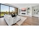 Bright living room featuring a fireplace, built-in shelves, hardwood floors, and views of the outdoor scenery at 6331 E Phoenician Blvd # 6, Scottsdale, AZ 85251