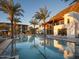 Resort-style pool surrounded by palm trees, lounge chairs, and a modern building at 6331 E Phoenician Blvd # 6, Scottsdale, AZ 85251
