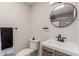 Modern bathroom featuring a round mirror, stylish vanity, and sleek fixtures at 7807 E Palm Ln, Scottsdale, AZ 85257
