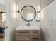 Modern bathroom with a sleek vanity, round mirror, and stylish sconce lighting at 7807 E Palm Ln, Scottsdale, AZ 85257