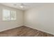 Bright bedroom with wood-look flooring, ceiling fan, and plantation shutters at 7807 E Palm Ln, Scottsdale, AZ 85257