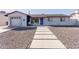 Charming home featuring decorative gravel, a concrete walkway, and a vibrant blue front door at 7807 E Palm Ln, Scottsdale, AZ 85257