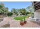 Lush backyard featuring manicured lawn, stone patio, and mature trees provides a serene outdoor retreat at 9621 N 83Rd Way, Scottsdale, AZ 85258