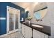 Elegant bathroom with white cabinets, black countertop, decorative tile and round mirrors at 9621 N 83Rd Way, Scottsdale, AZ 85258