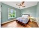 Cozy bedroom with a queen bed, ceiling fan, and a large window overlooking the landscaped yard at 9621 N 83Rd Way, Scottsdale, AZ 85258