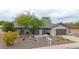 Single-story home with desert landscaping features a warm paint and a beautiful mature tree in the front yard at 9621 N 83Rd Way, Scottsdale, AZ 85258