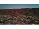 Overhead shot of a residential area nestled against a mountain, with homes lit up in the evening at 9835 S 11Th St, Phoenix, AZ 85042