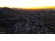 Stunning aerial view of the community illuminated at dusk, backed by scenic mountains and vibrant sky at 9835 S 11Th St, Phoenix, AZ 85042