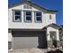 Two-story home with a gray garage door, stone accents, and a white stucco exterior at 9835 S 11Th St, Phoenix, AZ 85042