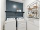 Functional laundry room with modern washer and dryer, ample shelving, and a stylish design at 9835 S 11Th St, Phoenix, AZ 85042