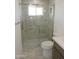 Modern bathroom with glass-enclosed shower, neutral tile, and bright natural light at 9923 W Hope N Cir, Sun City, AZ 85351