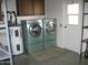 Functional laundry room with washer, dryer, water heater, and storage space at 10334 W Highwood Ln, Sun City, AZ 85373