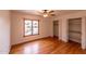 Comfortable bedroom with hardwood floors, a window overlooking the pool, and closet space at 10421 N 77Th Pl, Scottsdale, AZ 85258