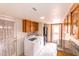 Functional laundry room with ample storage, granite countertops, and a window at 10421 N 77Th Pl, Scottsdale, AZ 85258