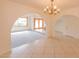 Open-concept living room featuring a large chandelier, beautiful tile flooring, and natural light at 10421 N 77Th Pl, Scottsdale, AZ 85258