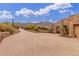 Wide driveway leads up to a stone home with cacti and desert landscaping and mountain views at 10955 E Vista Del Cielo Rd, Gold Canyon, AZ 85118