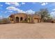 Exterior stone elevation with a two-car garage, desert landscaping, and wrought iron gated entrance at 10955 E Vista Del Cielo Rd, Gold Canyon, AZ 85118