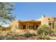 A Southwest home showcasing a tiled roof, stone accents, and mature desert landscaping at 10955 E Vista Del Cielo Rd, Gold Canyon, AZ 85118