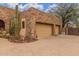 Close-up of an attached two-car garage with stone exterior and desert landscaping at 10955 E Vista Del Cielo Rd, Gold Canyon, AZ 85118