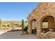 Close up of an iron gated entry with stone archways and desert landscaping with mountain views at 10955 E Vista Del Cielo Rd, Gold Canyon, AZ 85118