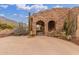 Iron gated entry with desert landscaping, cactus, and stone archways to this desert home at 10955 E Vista Del Cielo Rd, Gold Canyon, AZ 85118