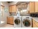 Functional laundry room featuring matching washer and dryer, cabinets, and a sink at 10955 E Vista Del Cielo Rd, Gold Canyon, AZ 85118