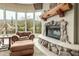 Cozy seating area with a stone fireplace and scenic views through large windows at 10955 E Vista Del Cielo Rd, Gold Canyon, AZ 85118