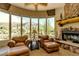 Cozy reading nook showcases mountain views, a stone fireplace, and comfortable leather chairs at 10955 E Vista Del Cielo Rd, Gold Canyon, AZ 85118